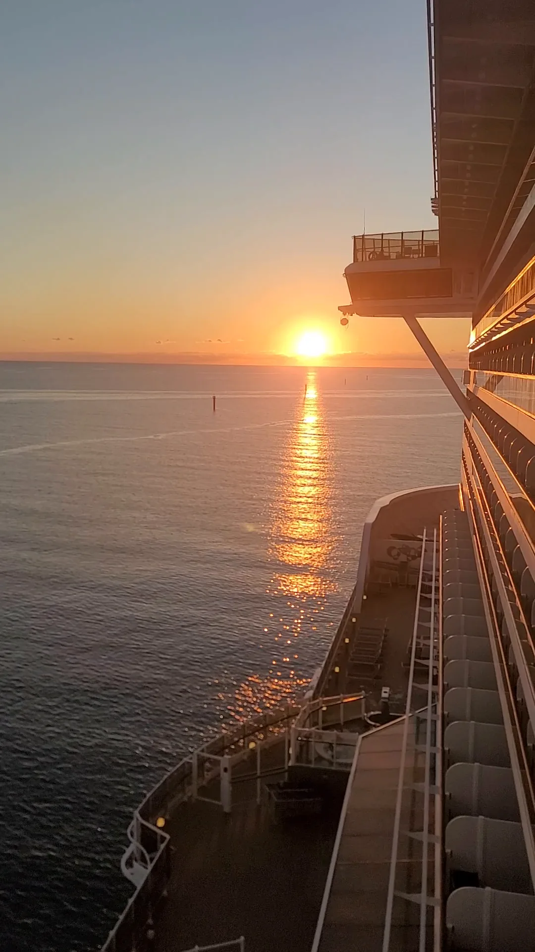 Sunset over the ocean, seen from the side of a cruise ship